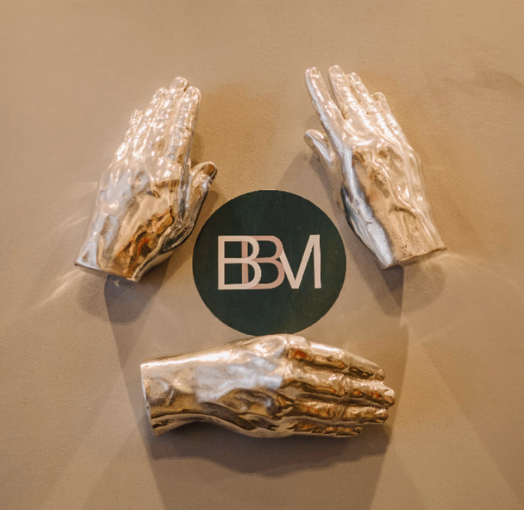 Elementos decorativos com mãos escultóricas e identidade visual da BBM Advocacia em ambiente corporativo do escritório.