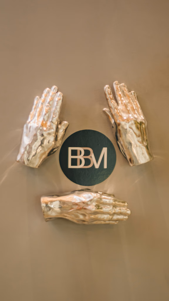 Elementos decorativos com mãos escultóricas e identidade visual da BBM Advocacia.