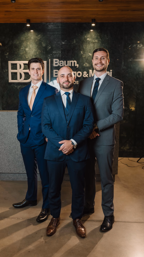 Os advogados Caio Baum, Carlos Milani e Giovani Beirigo, fundadores da BBM Advocacia, em ambiente corporativo no escritório.